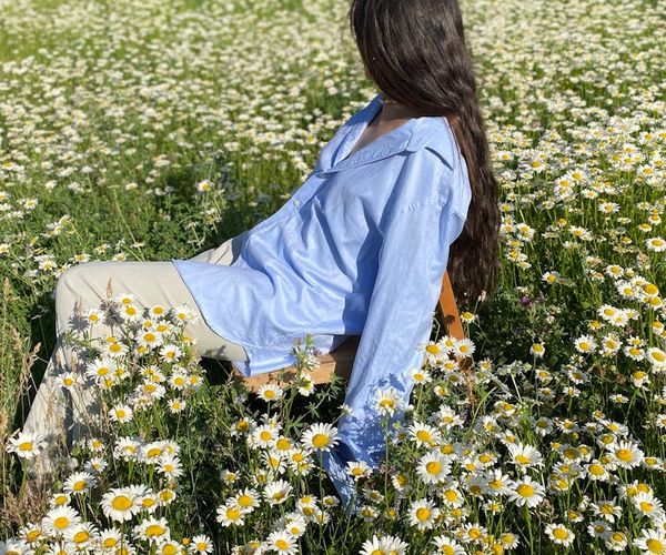 Person stretching gently outdoors with a serene natural background.