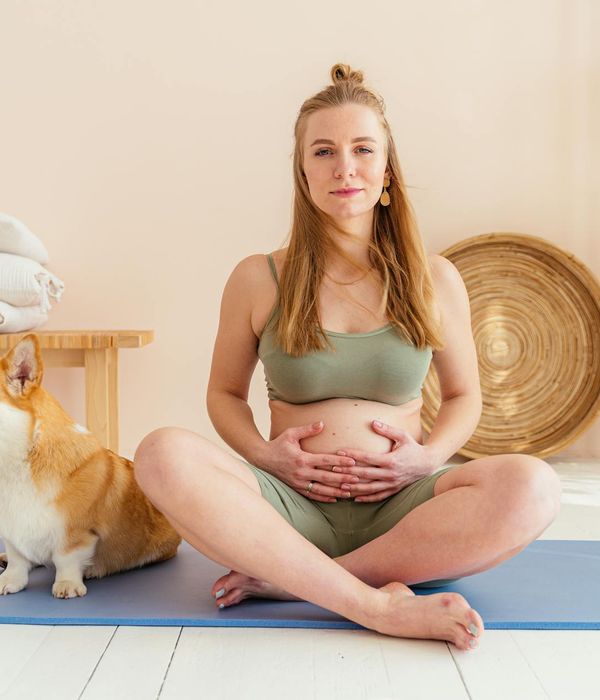 Woman smiling during a light cardio exercise in a bright, airy room.